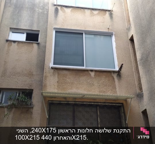 חלון אלומיניום עם מסגרת לבנה על קיר חיצוני